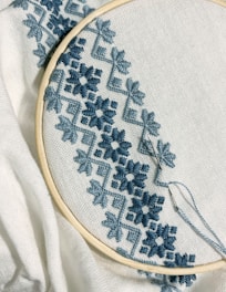 A close up of a embroidery on a white cloth