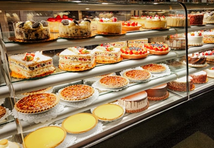A display case filled with lots of cakes and pies