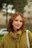 A woman with red hair is standing in the grass