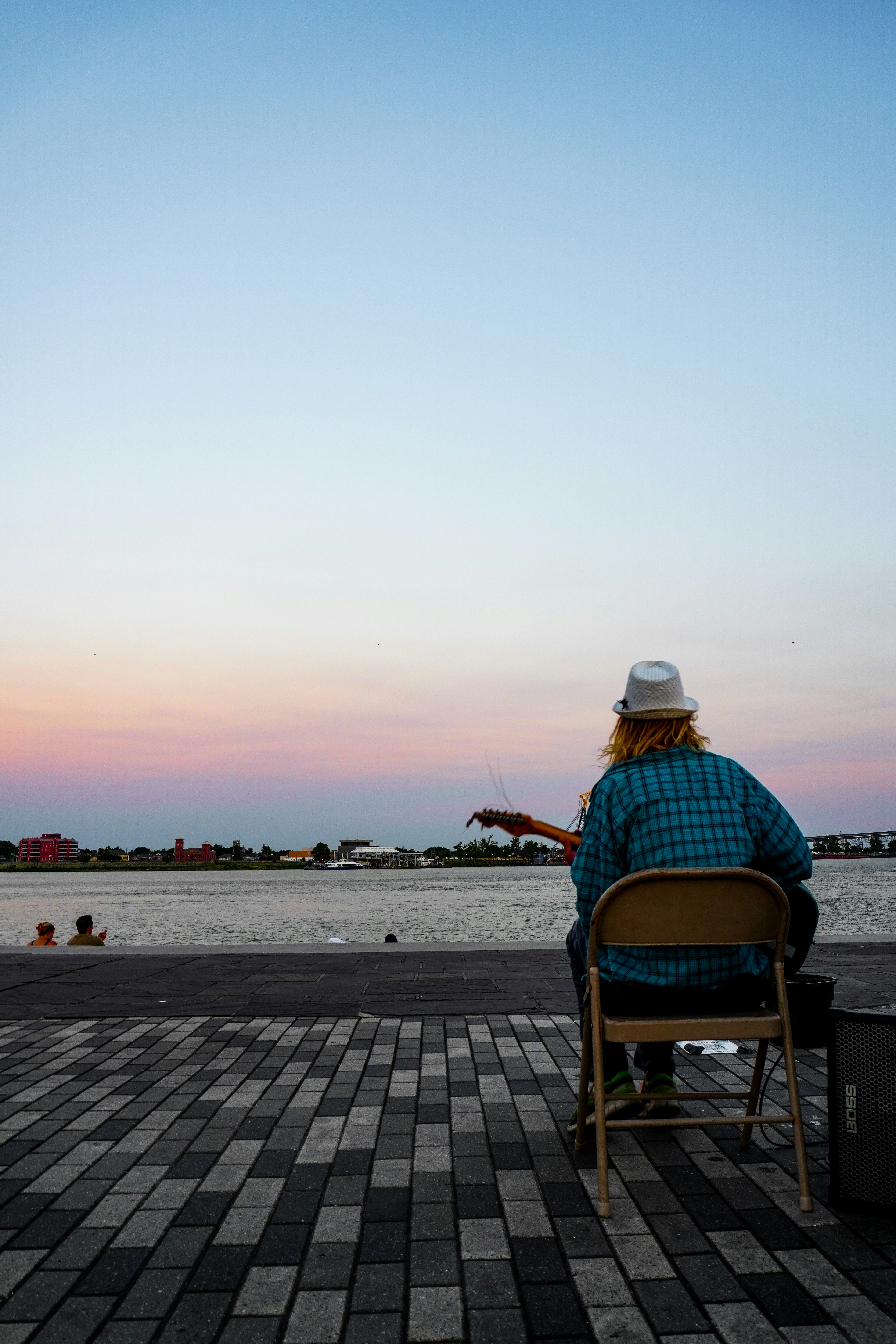 水辺の近くの椅子に座っている人