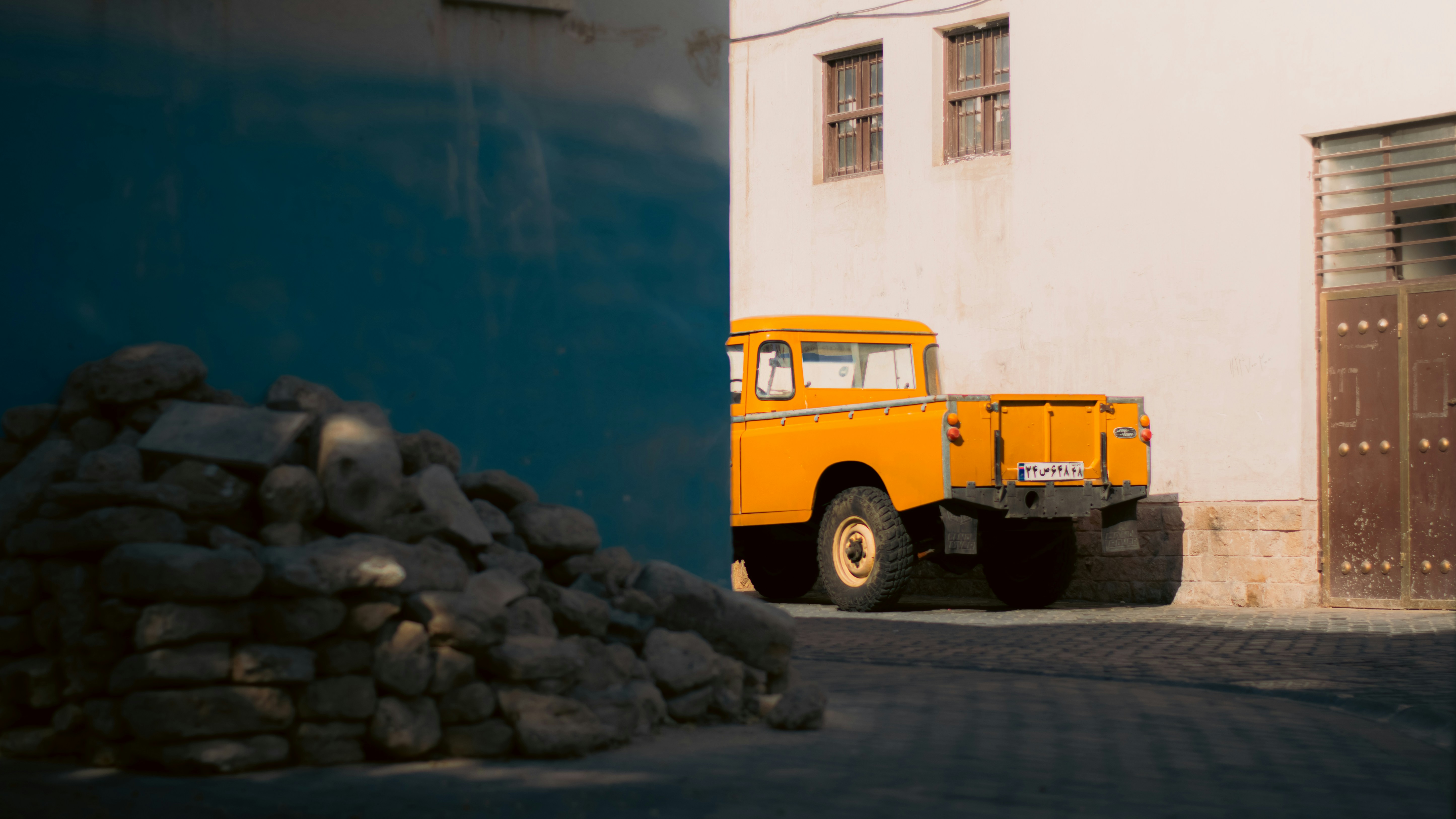 A yellow truck is parked in front of a building