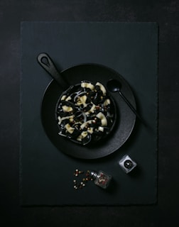 A black plate topped with food next to a camera