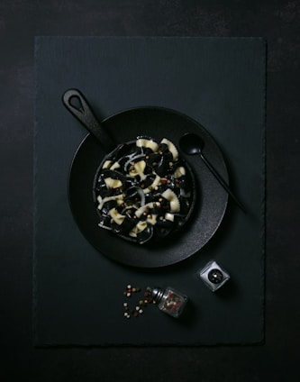 A black plate topped with food next to a camera