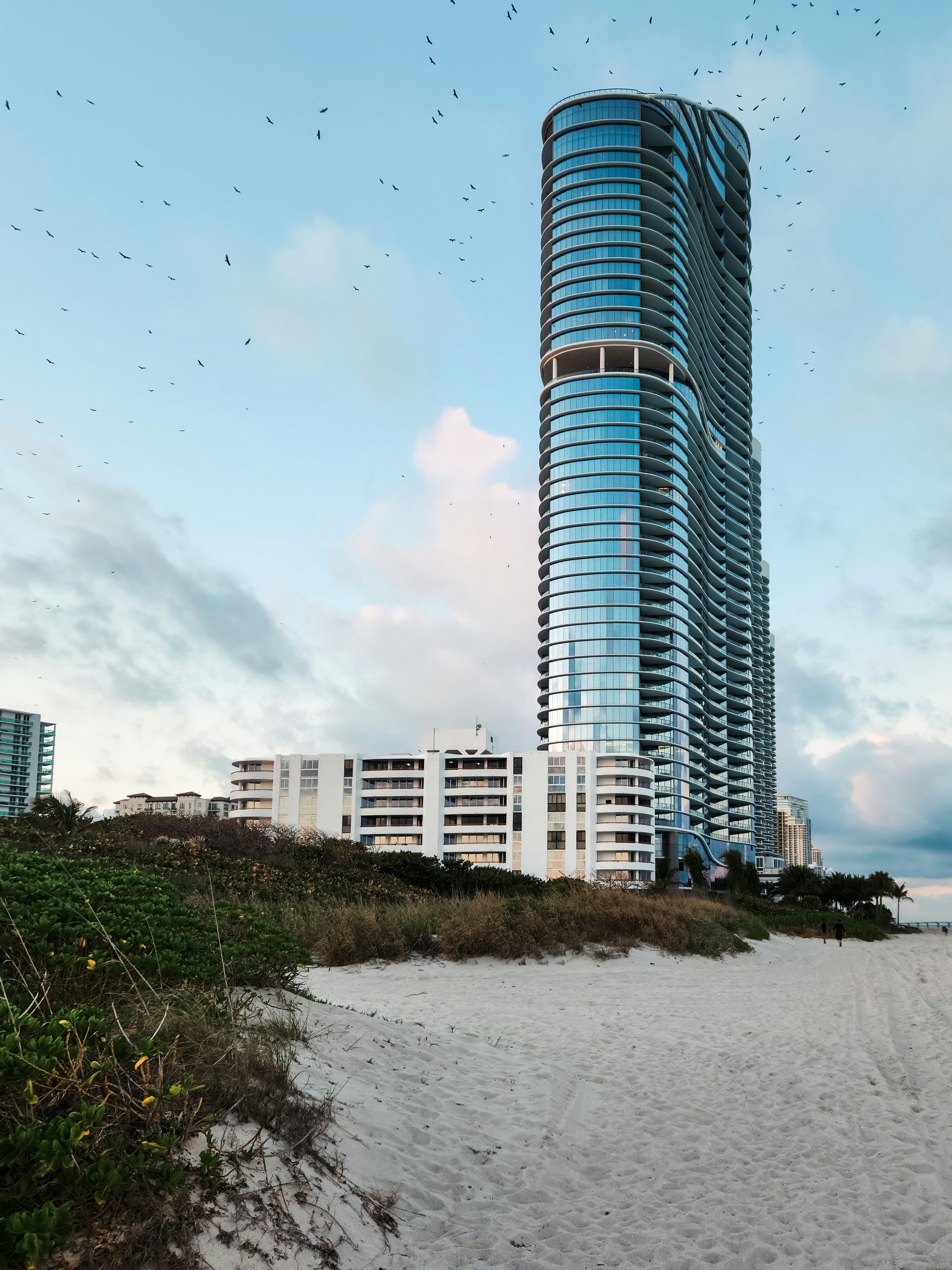 A tall building sitting on top of a sandy beach