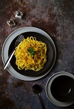 A plate of spaghetti and a cup of coffee