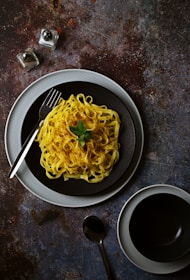 A plate of spaghetti and a cup of coffee