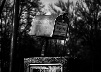 A black and white photo of a mailbox