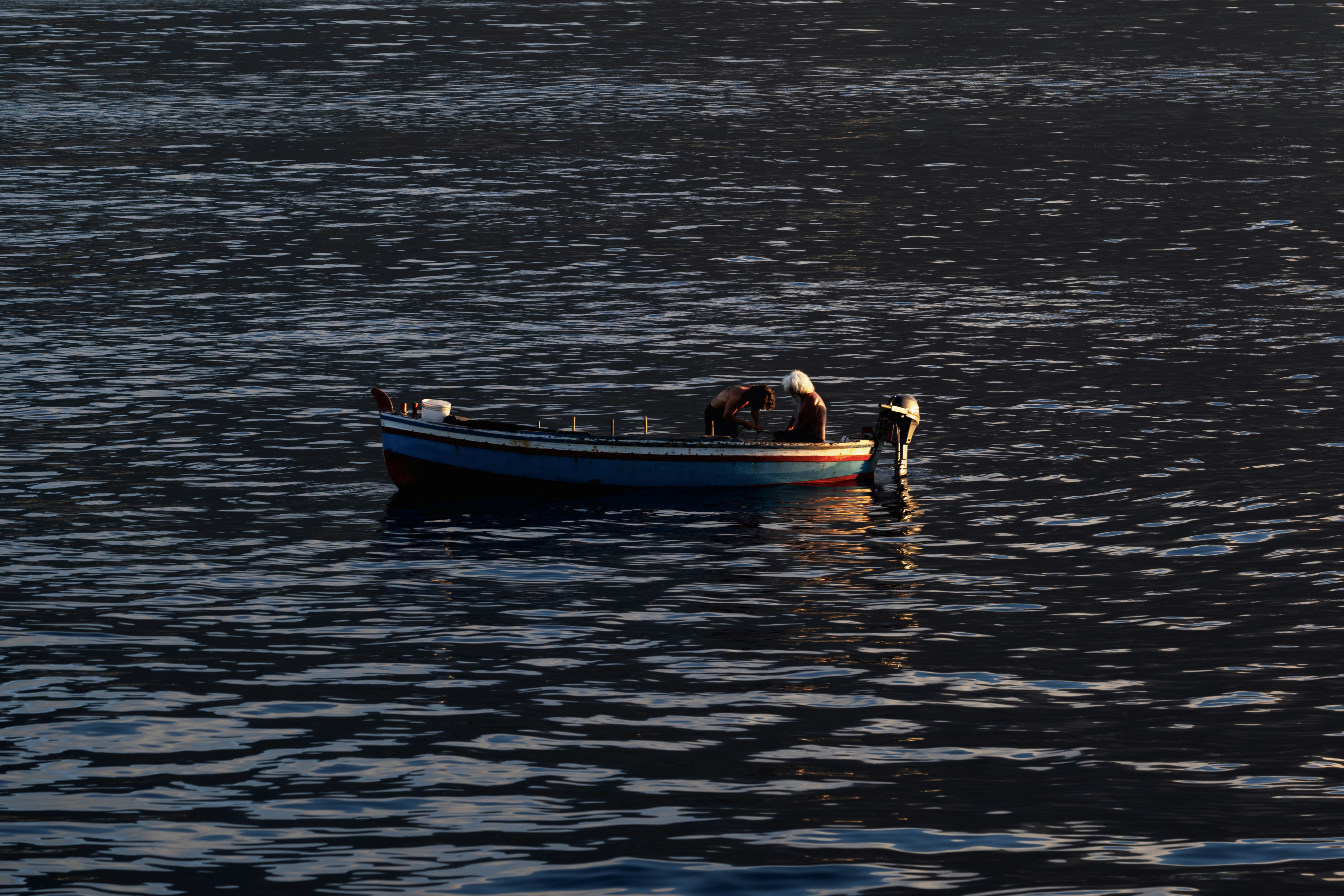 A small boat floating on top of a large body of water