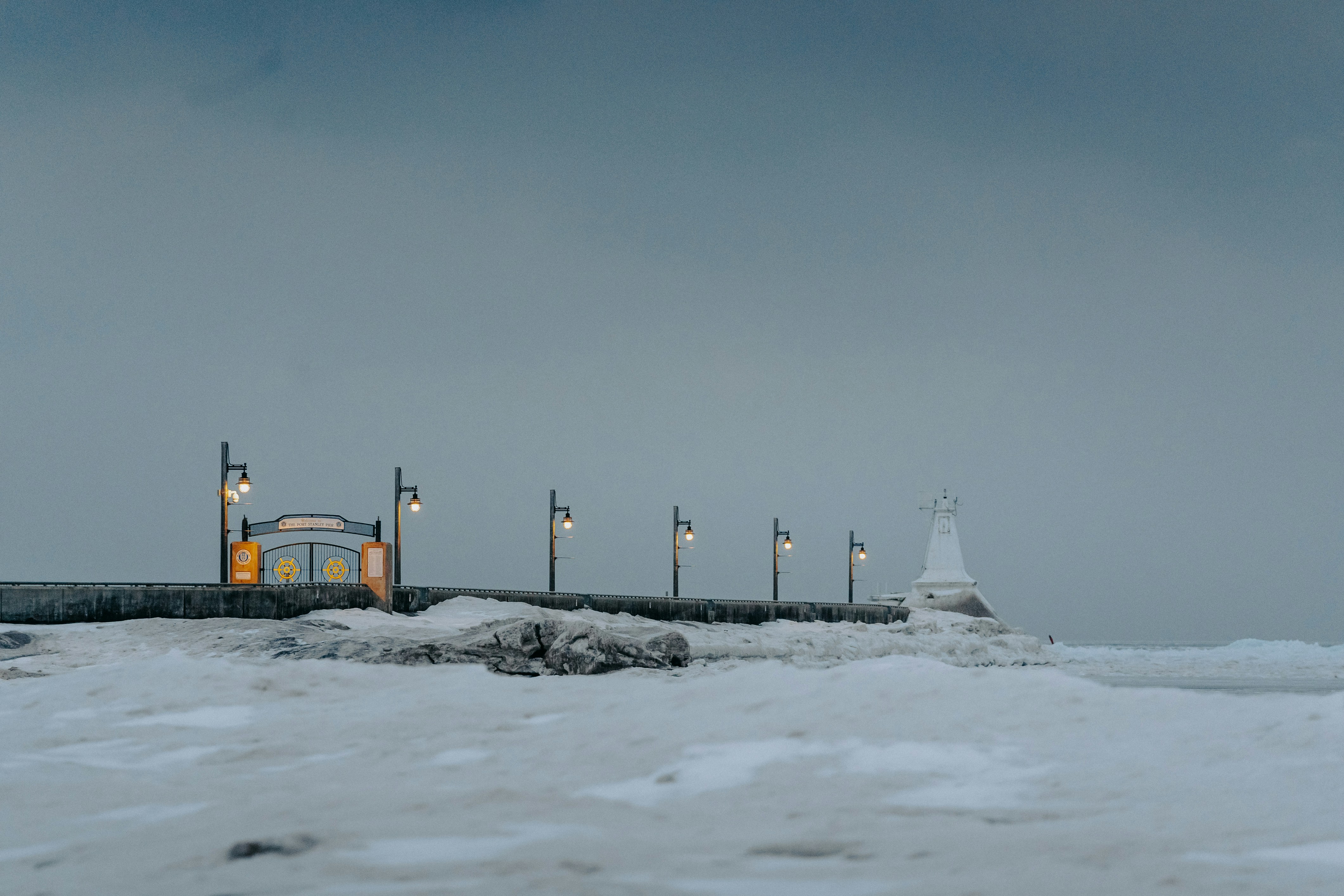 Une jetée recouverte de neige à côté d’un plan d’eau