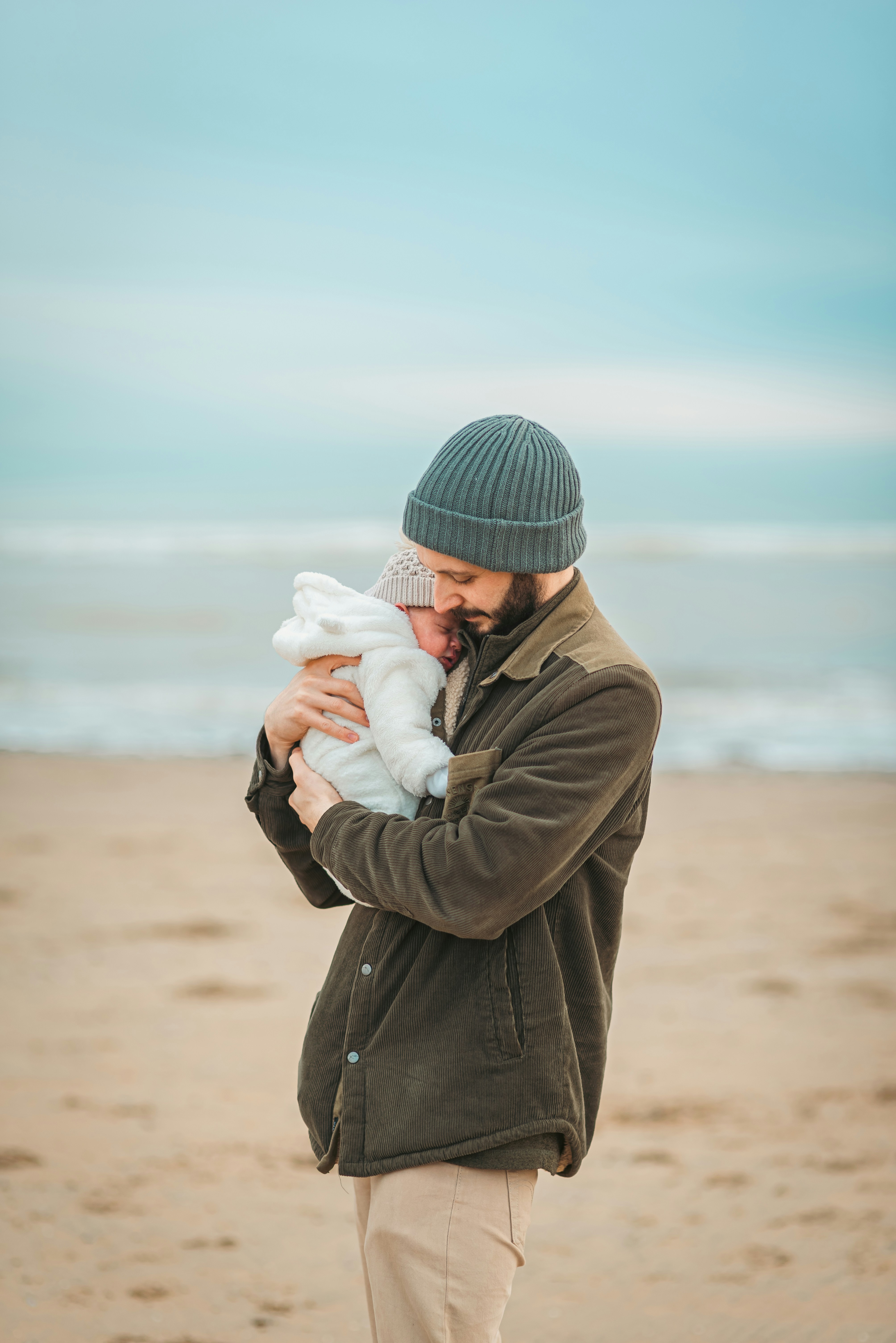 A man holding a baby on a beach