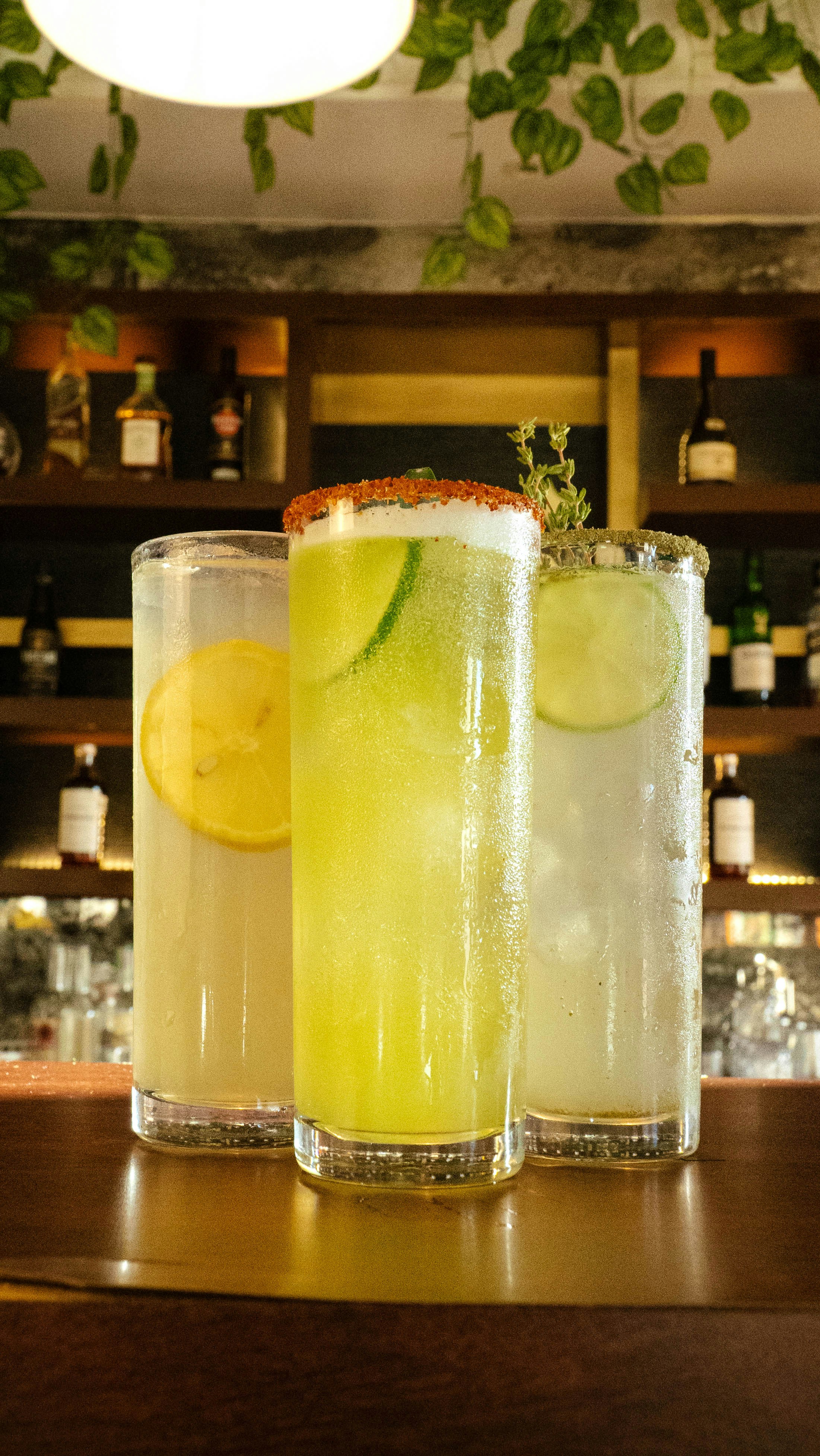 Three different types of drinks sitting on a bar