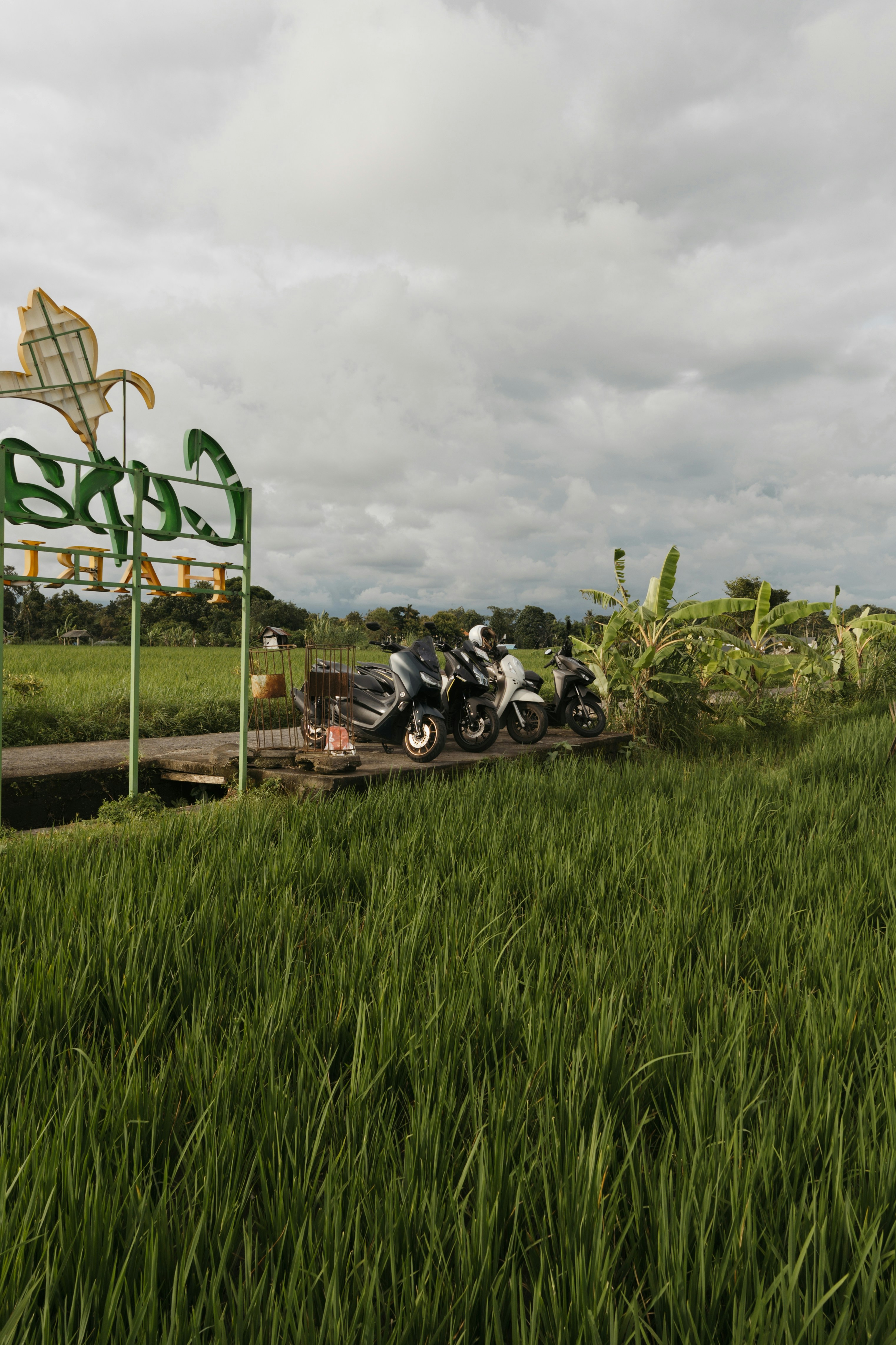 Sekelompok sepeda motor diparkir di sebelah lapangan hijau