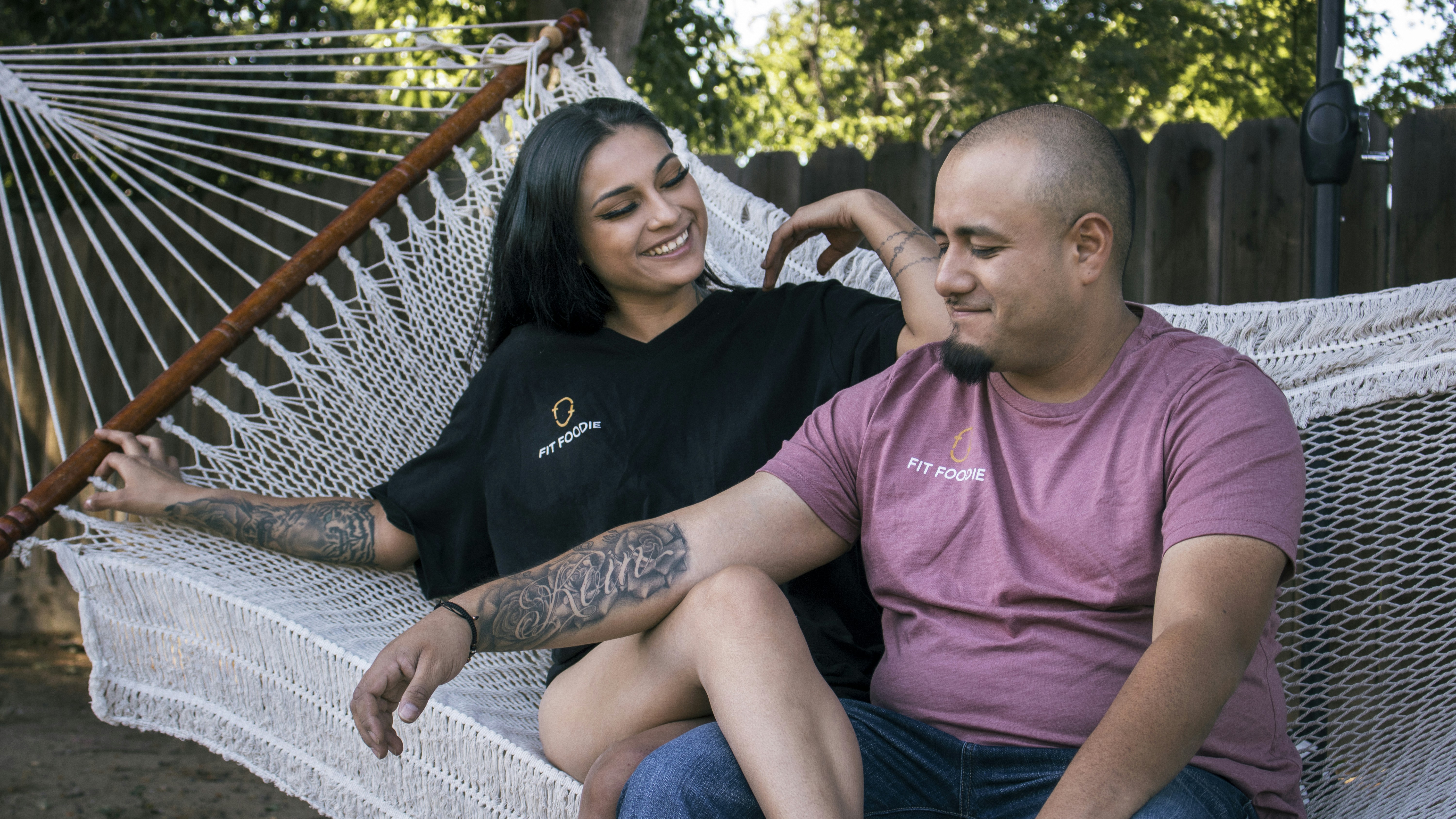 A man and a woman sitting on a hammock