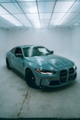 A blue sports car in a white room