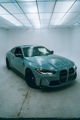 A blue sports car in a white room