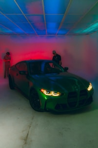 A man standing next to a car in a garage