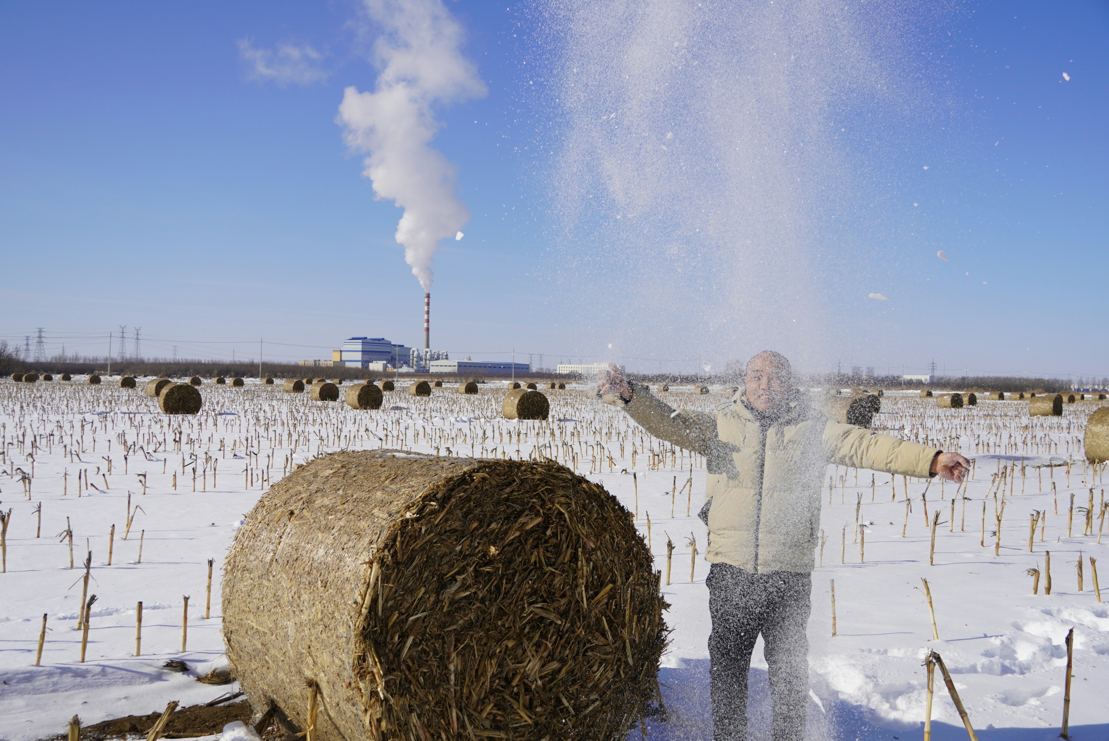 A man standing next to a bale of hay