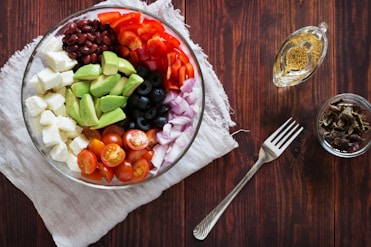 A bowl of fruit and vegetables on a wooden table
