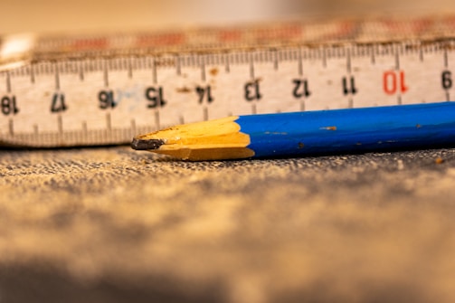 A ruler and a pencil laying on the floor