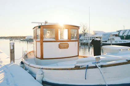A boat is docked in a snowy harbor