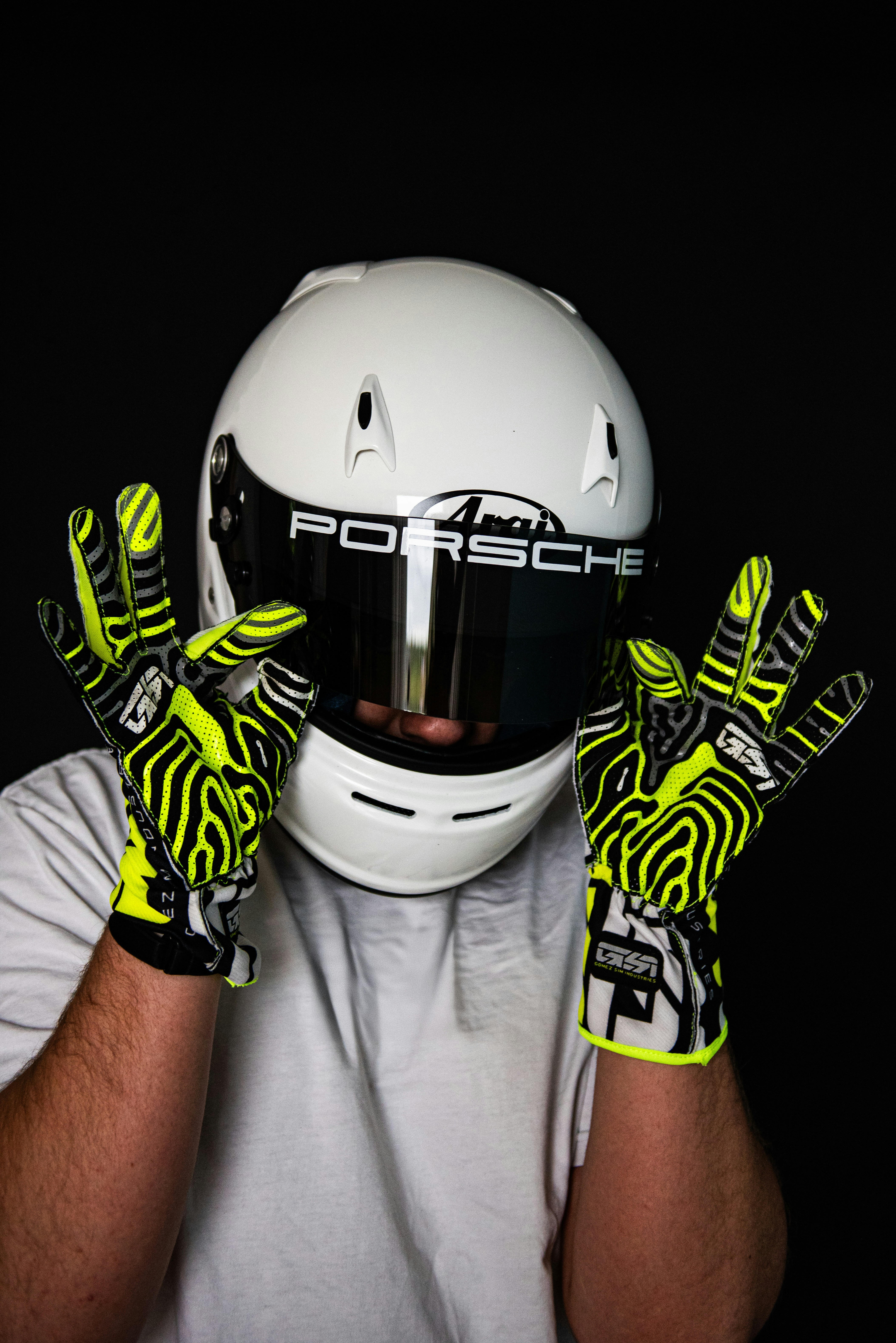 A man wearing a helmet and gloves holding his hands up to his face