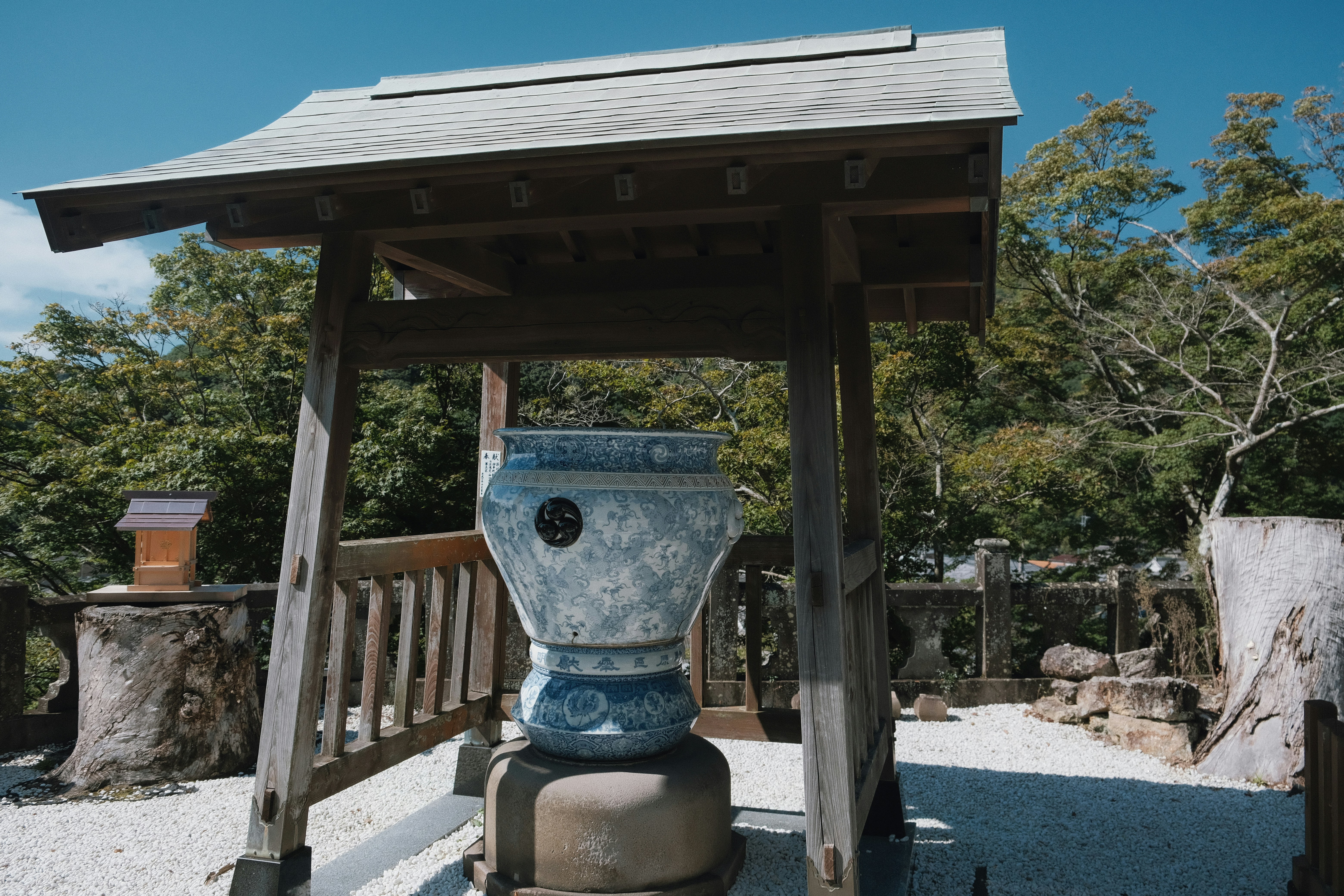 A blue and white vase sitting under a wooden structure