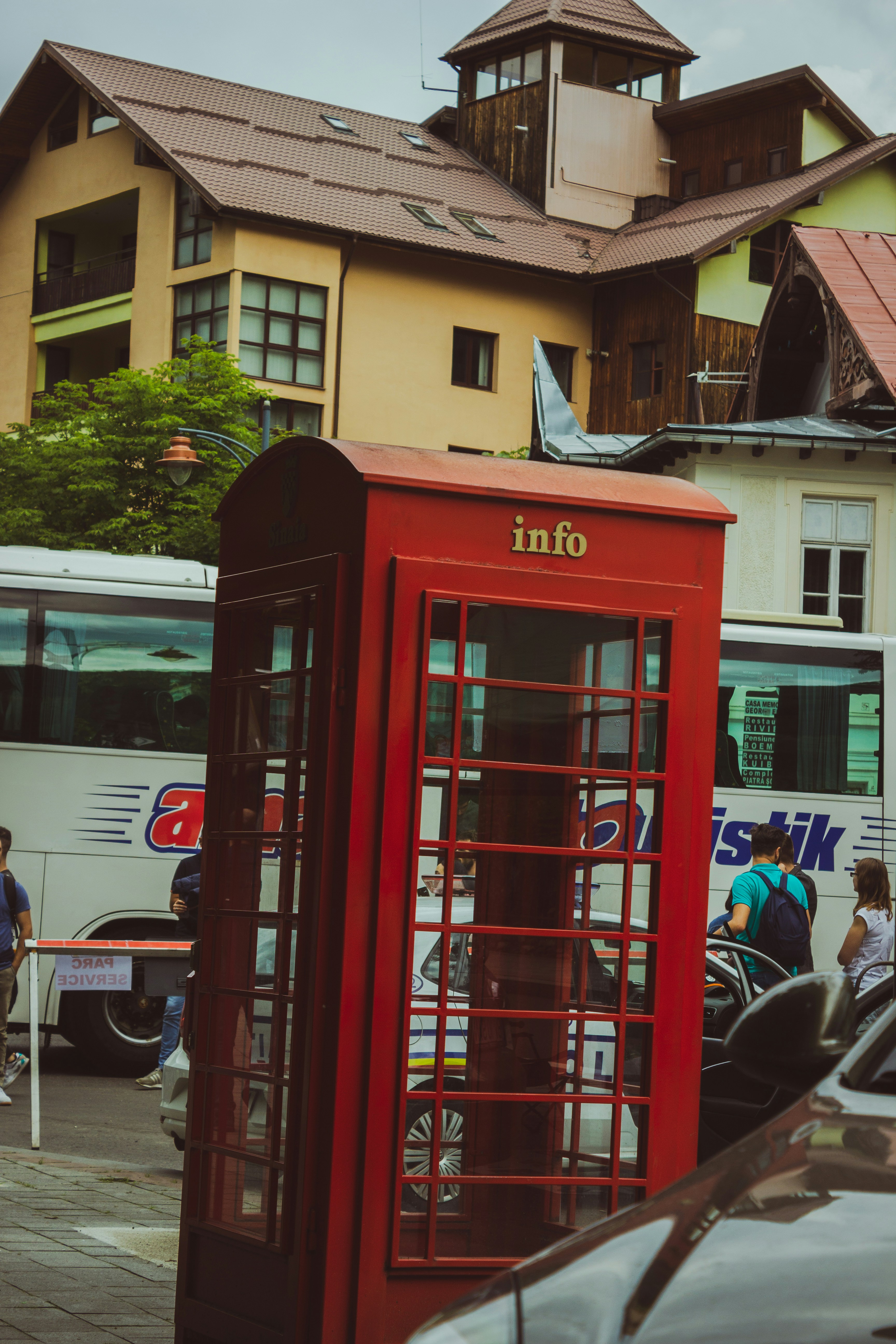 A red phone booth sitting on the side of a road