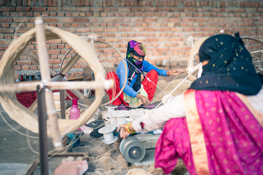 A woman spinning yarn at a traditional spinning wheel