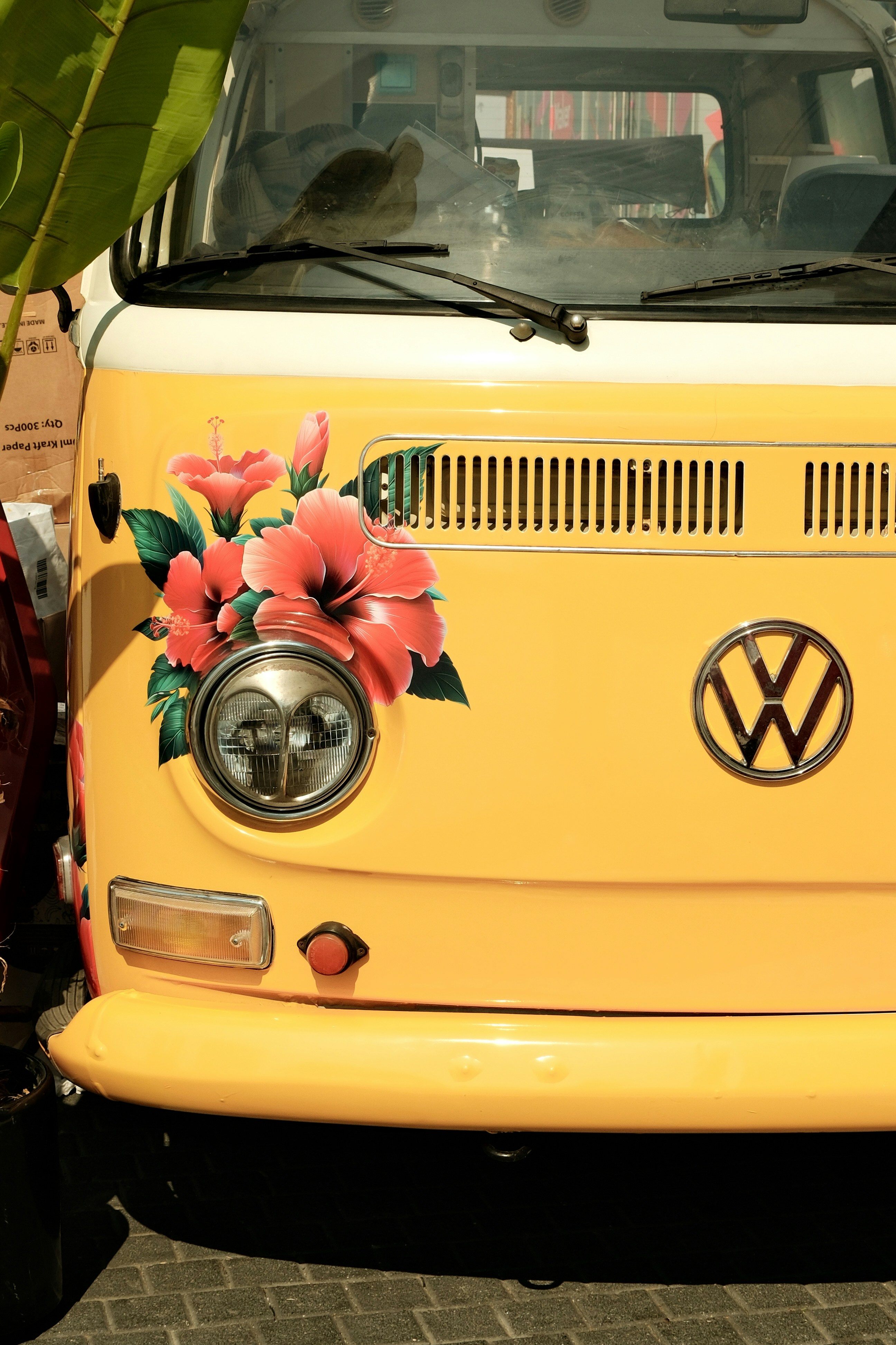 A yellow vw bus with flowers painted on it