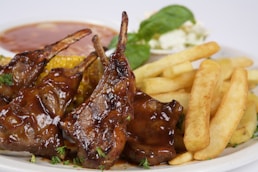 A white plate topped with meat and french fries