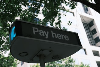 A sign that says pay here in front of a building