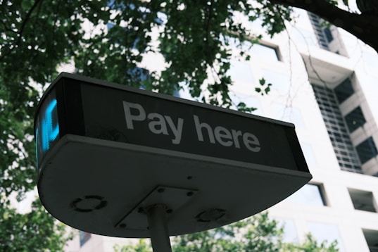 A sign that says pay here in front of a building