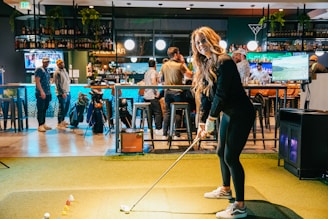 A woman playing a game of golf in a bar