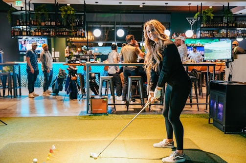 A woman playing a game of golf in a bar