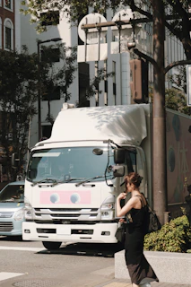 A woman crossing the street in front of a truck