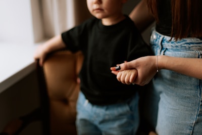 A little boy standing next to a woman