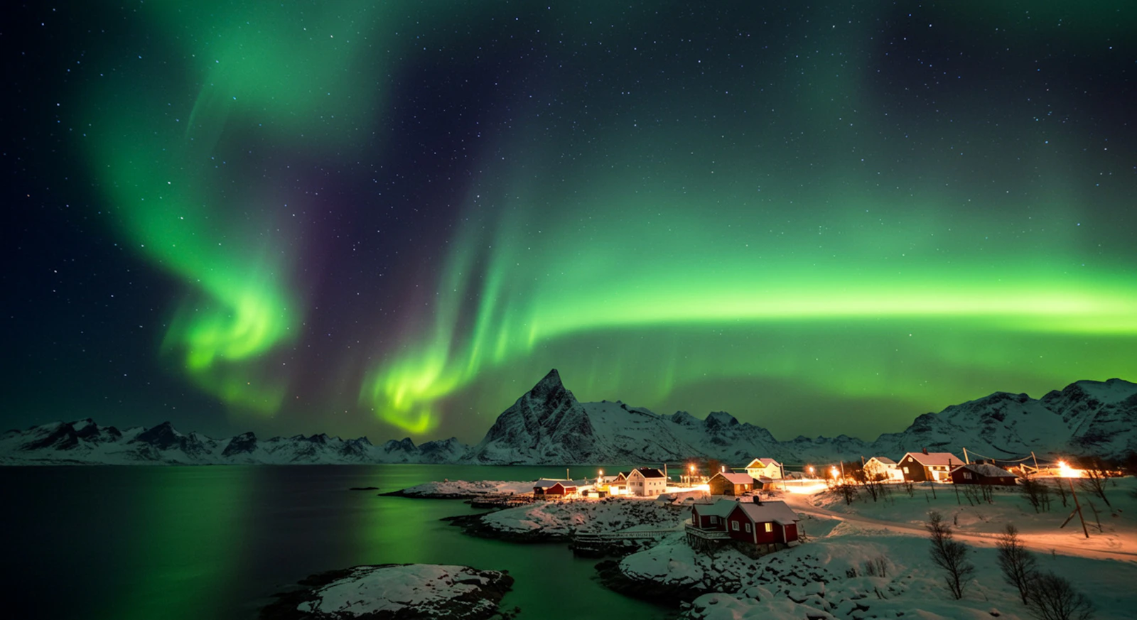 Green and purple aurora reflected in a lake under a starry sky in Norway