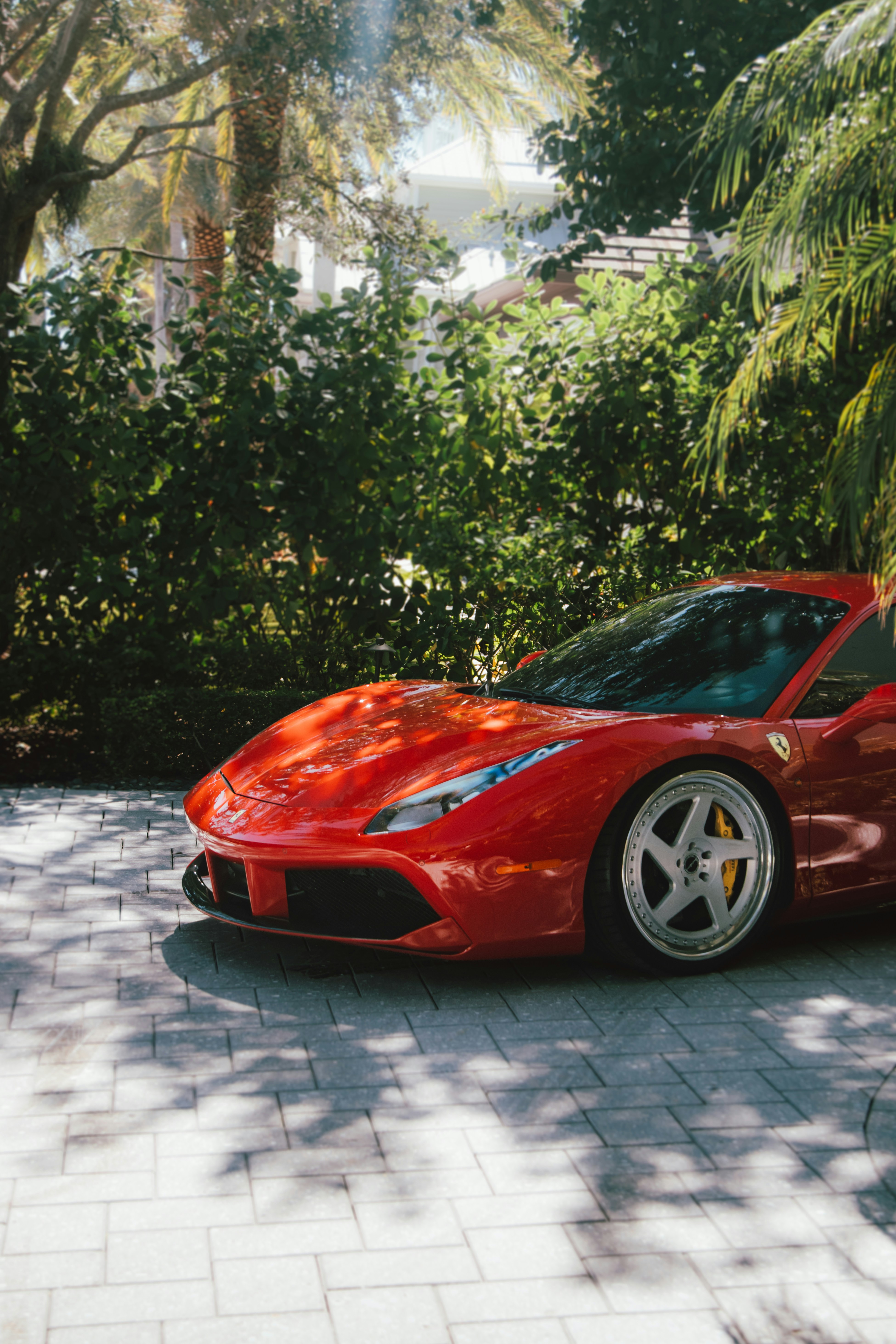 A red sports car parked in a driveway