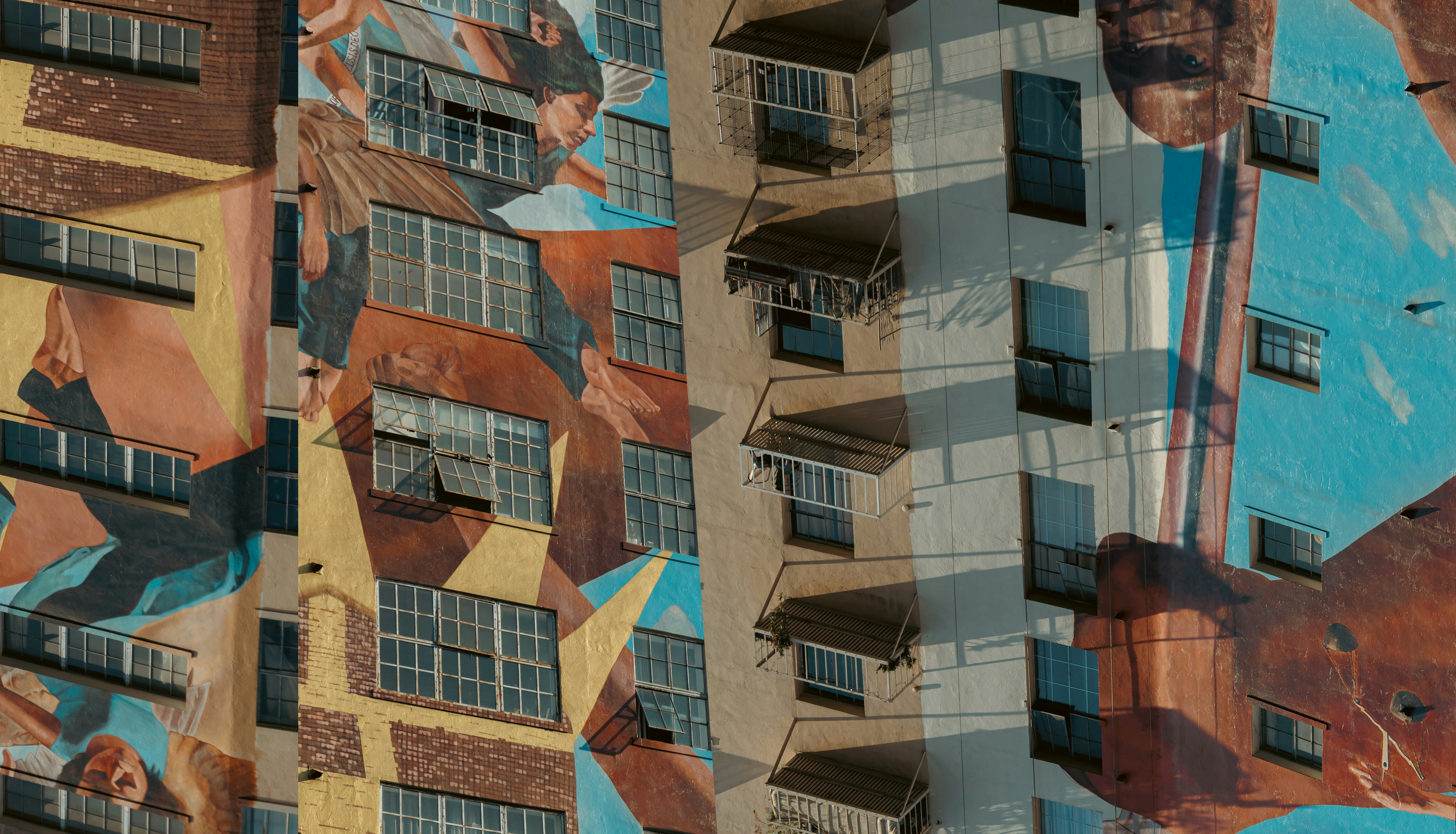 A tall building with a mural on the side of it, 