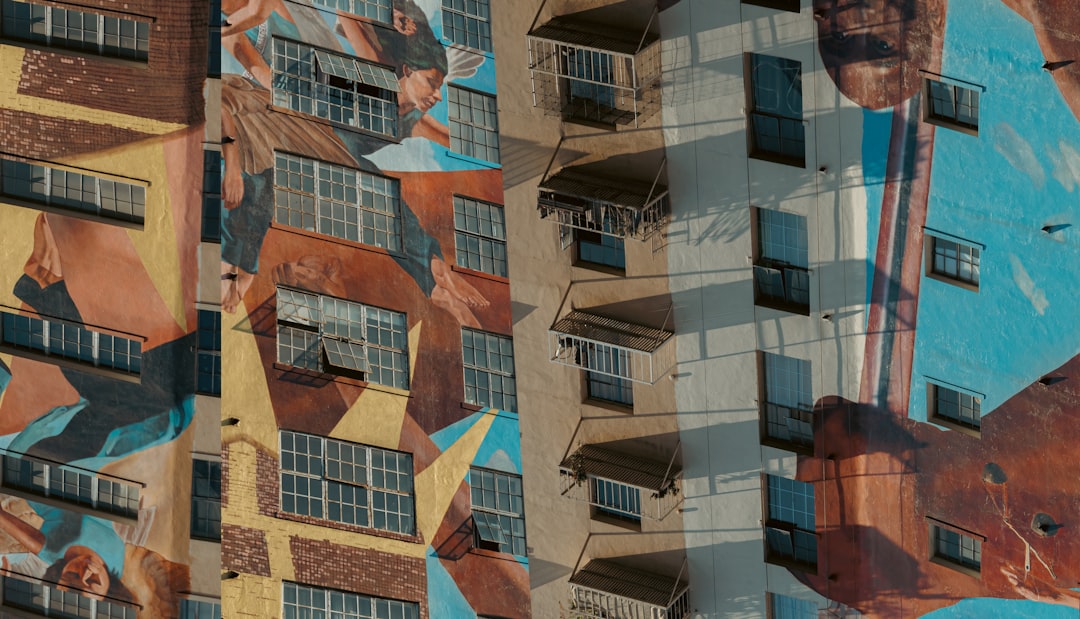 A tall building with a mural on the side of it,