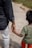 A man holding the hand of a small child
