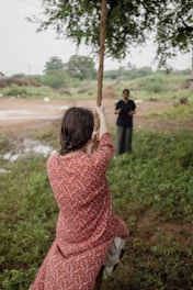 A woman in a red dress swinging on a rope