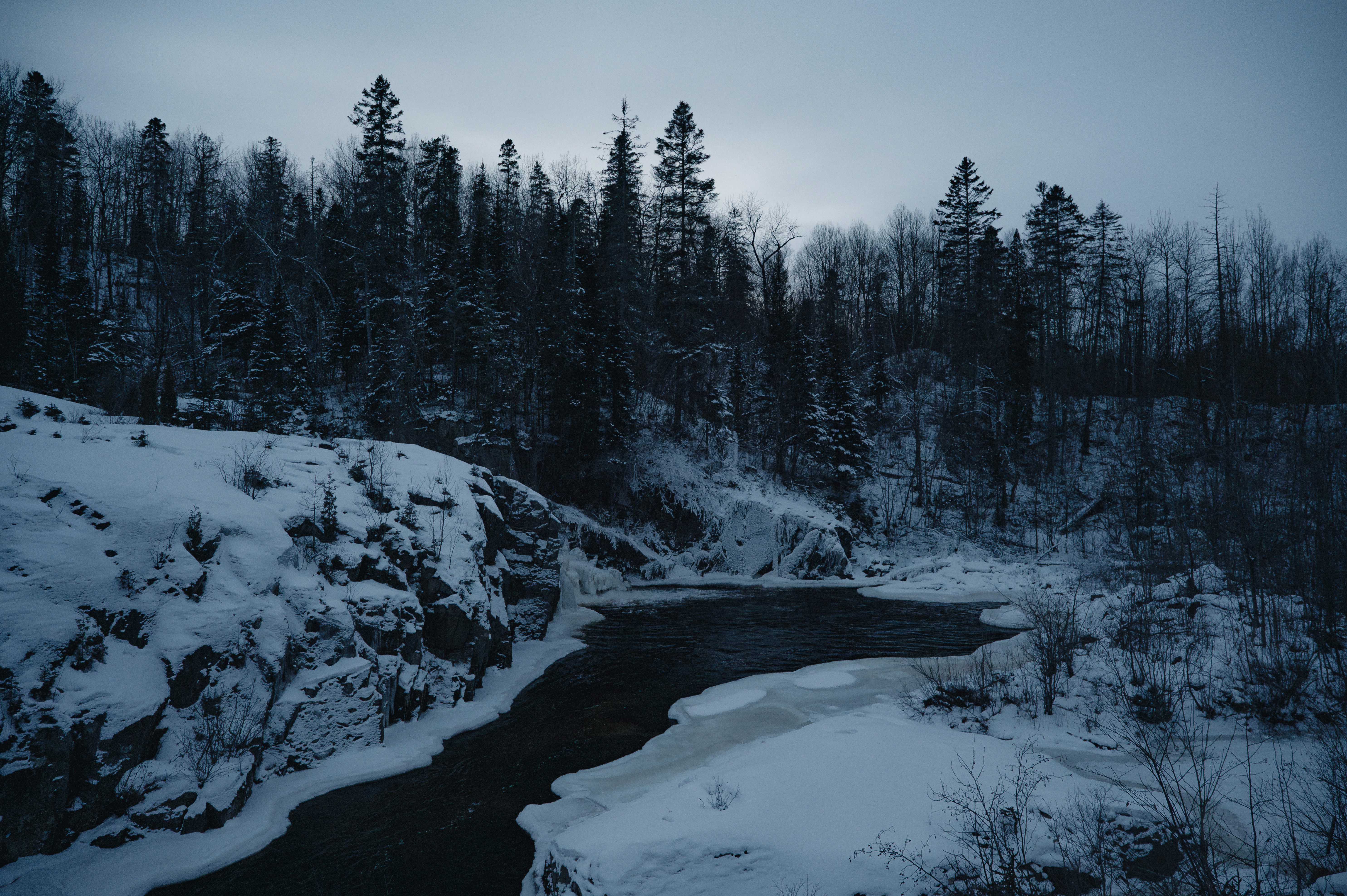 A river running through a snow covered forest