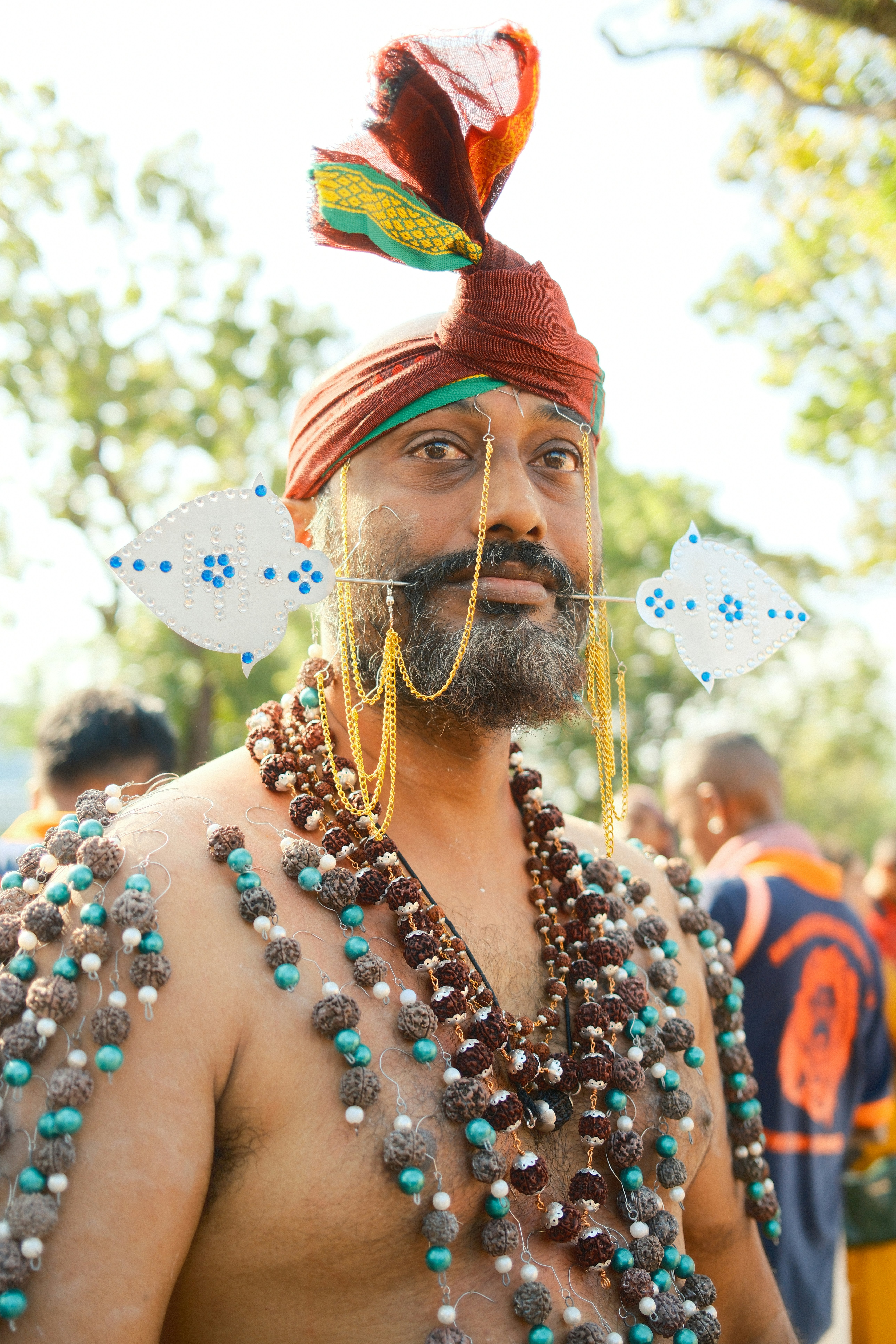 A man wearing a headdress and beads