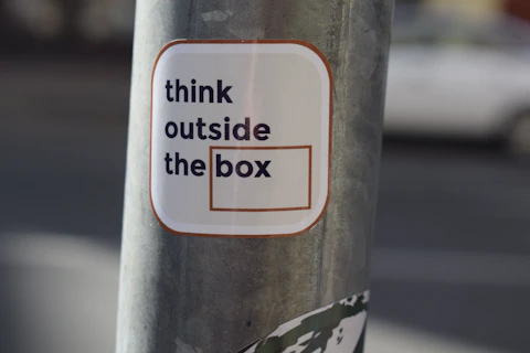 A sticker on a pole that says think outside the box