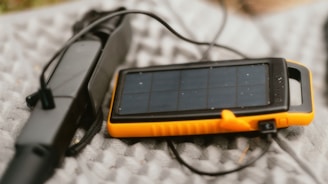 A solar powered device is laying on a blanket