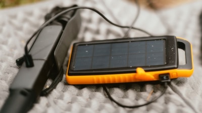 A solar powered device is laying on a blanket