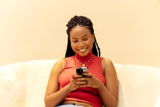 A woman sitting on a couch looking at her cell phone