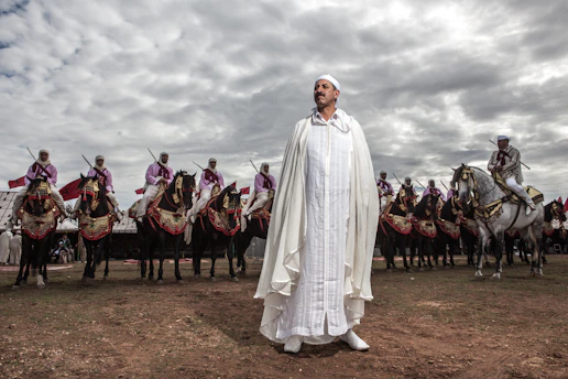 A man standing in front of a group of men on horses