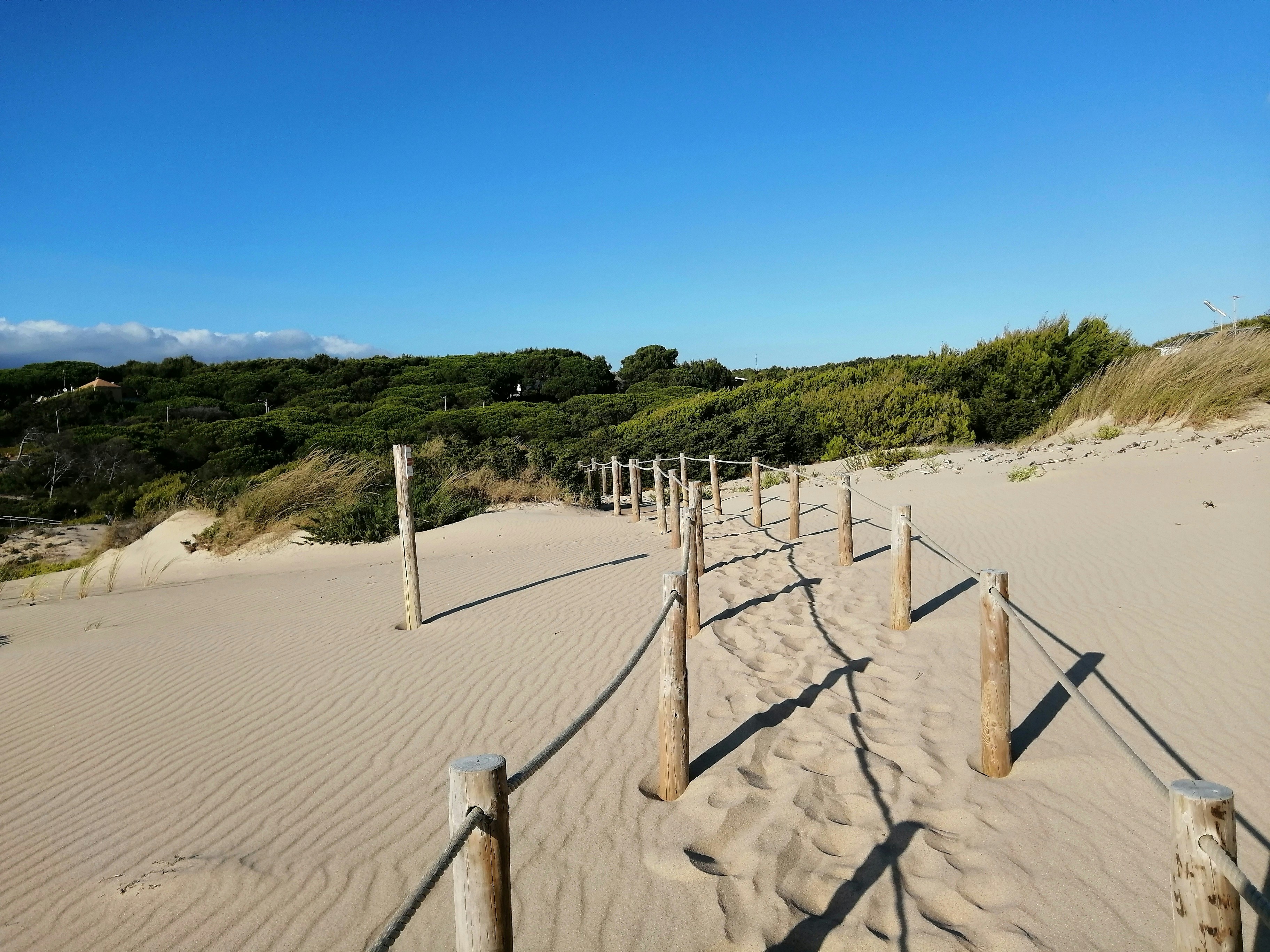 Ein Sandstrand mit Zaun und Sanddünen